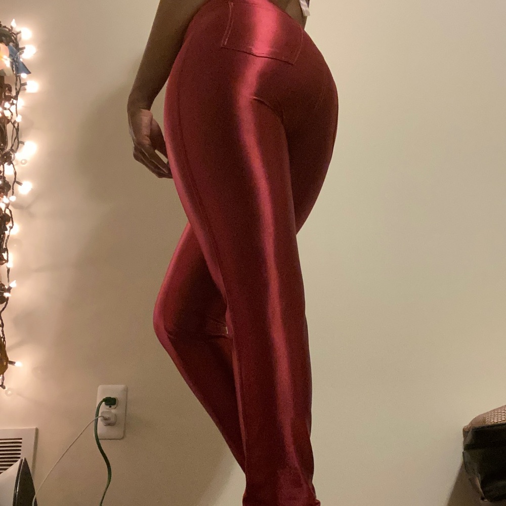 Burgundy shiny skinny jeans.